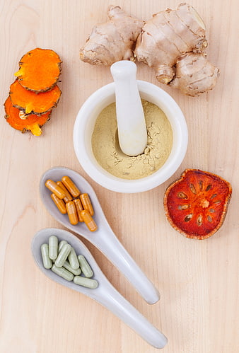 Natural herbal supplements and spices on wooden background
