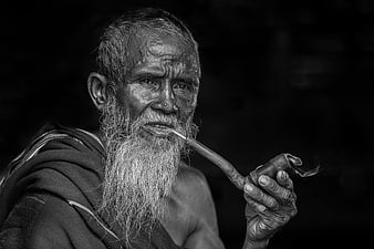Black and white portrait of an elderly man smoking a pipe