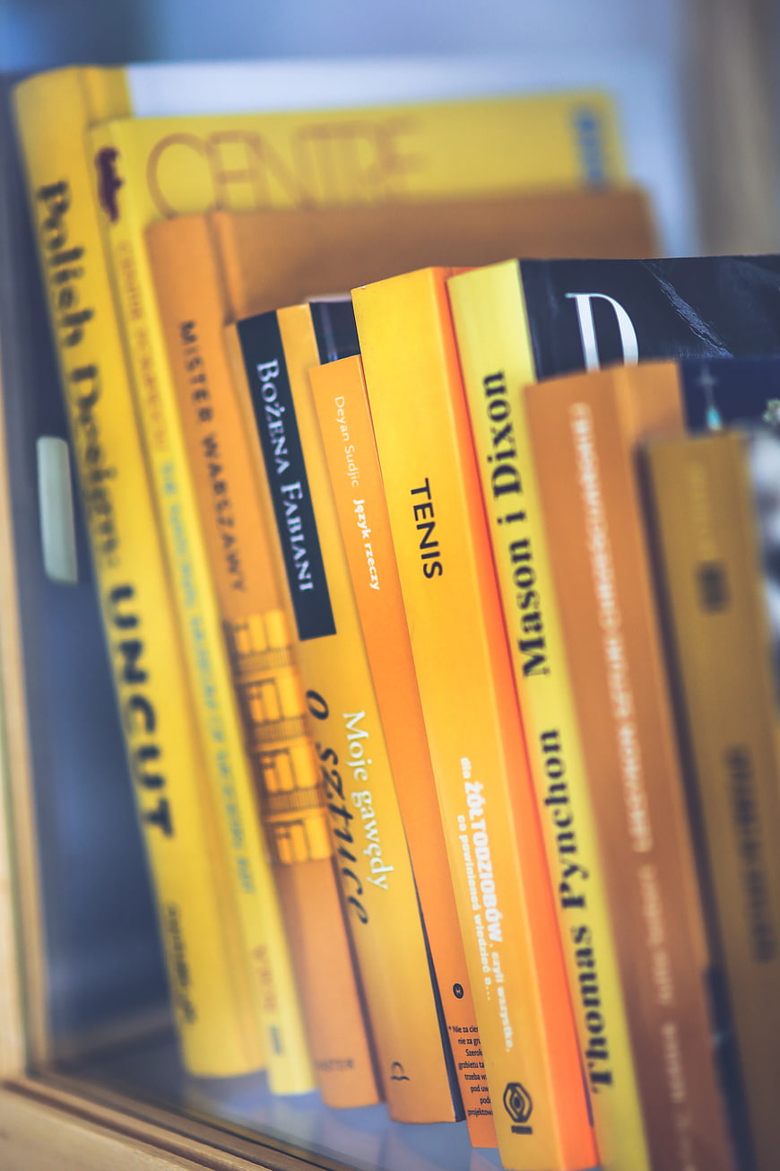 Close-up of yellow and orange book spines on a shelf