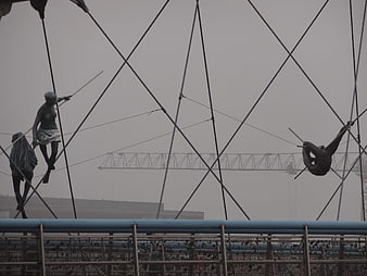 Foggy view of abstract metal sculptures on a bridge railing