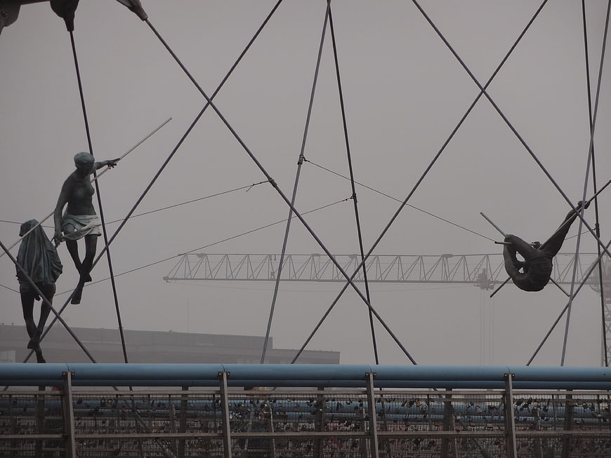 Foggy view of abstract metal sculptures on a bridge railing