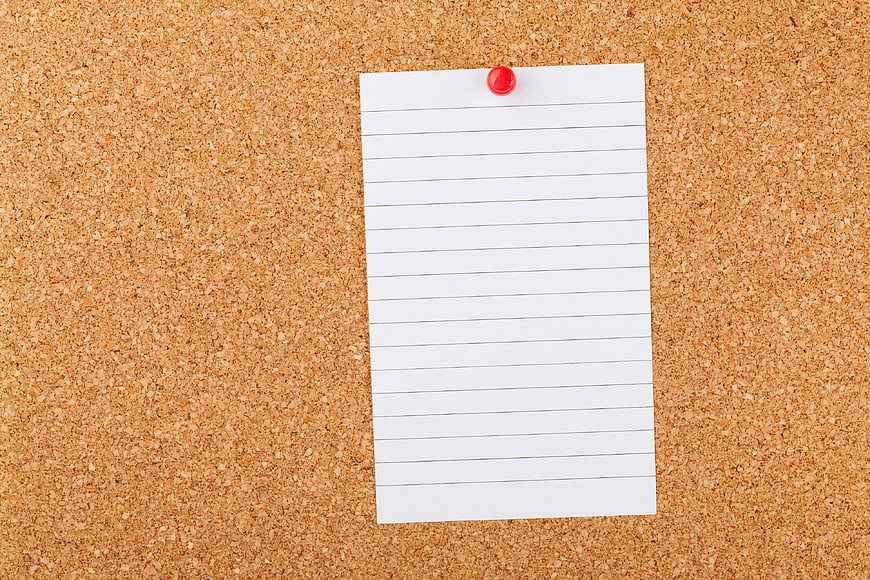 Blank Lined Memo Pad Pinned on Cork Board Background
