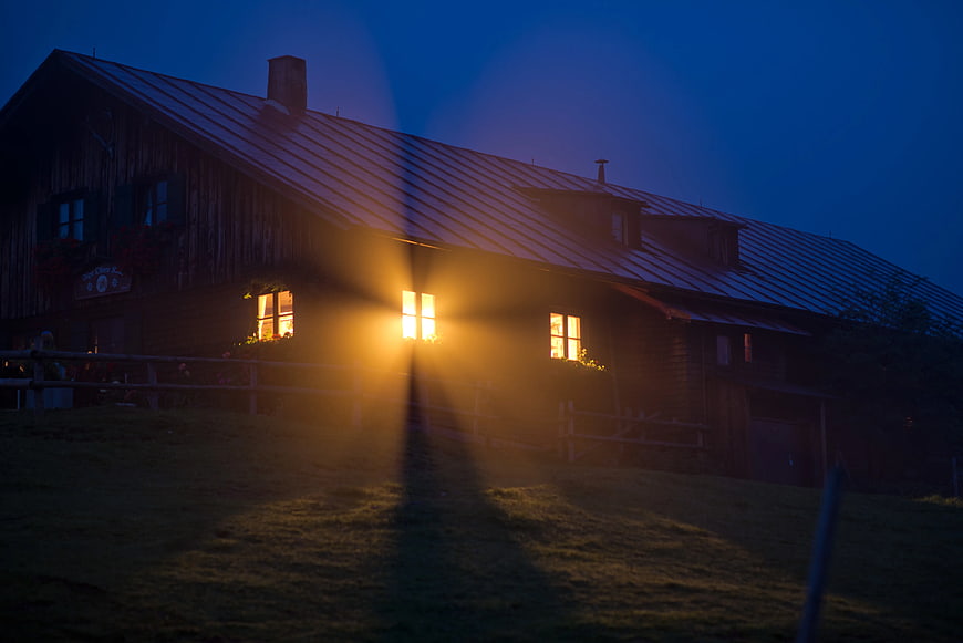 Rustic wooden house with glowing windows at night