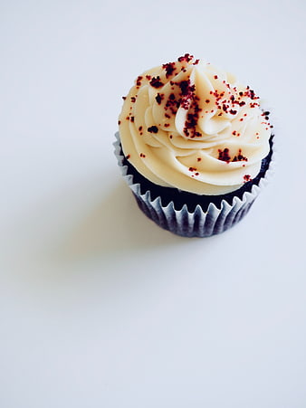 Chocolate Cupcake with Cream Frosting and Sprinkles on White Background