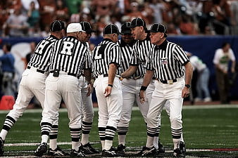 Group of football referees huddling on the field