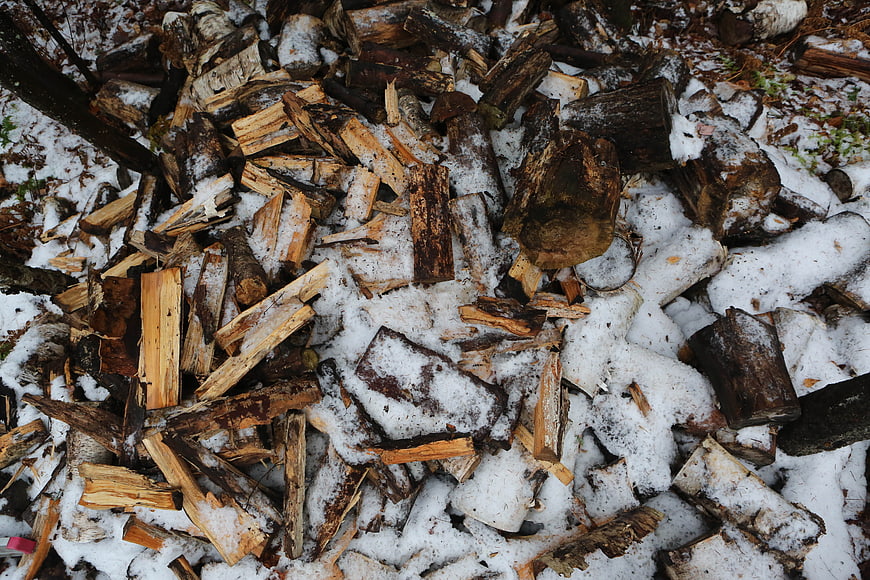 Pile of chopped firewood covered in snow
