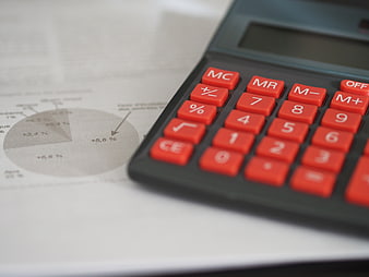 Close-up of calculator on financial report with pie chart