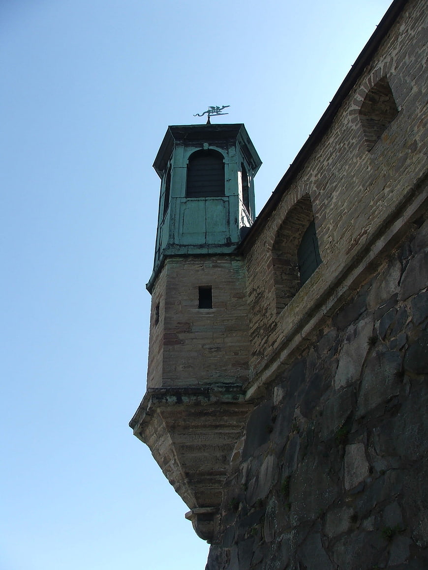 Low angle view of historic stone fortress tower against blue sky