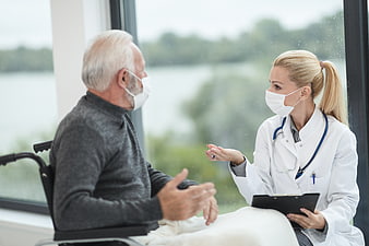 Senior Patient in Wheelchair Consulting with Female Doctor