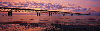 Panoramic Sunset View of Long Bridge Over Calm Ocean