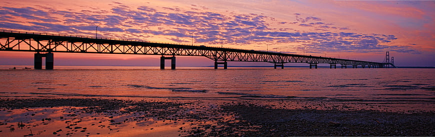 Panoramic Sunset View of Long Bridge Over Calm Ocean