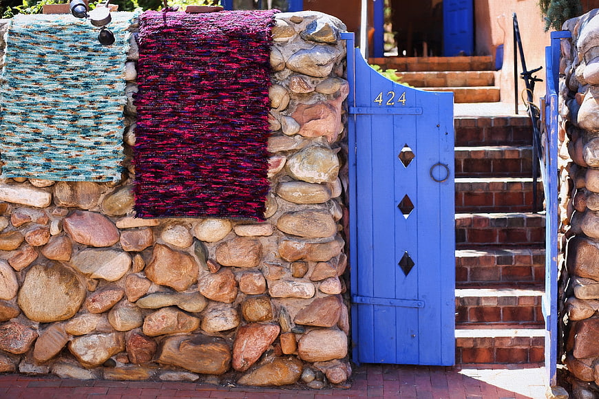Blue Door With Woven Textiles On Stone Wall In Santa Fe