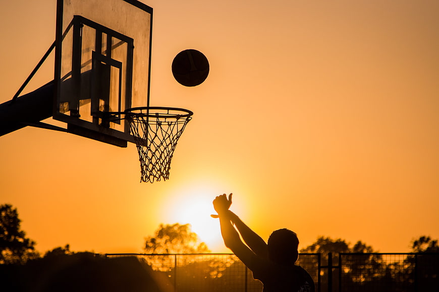 Silhouette of Basketball Player Shooting at Sunset