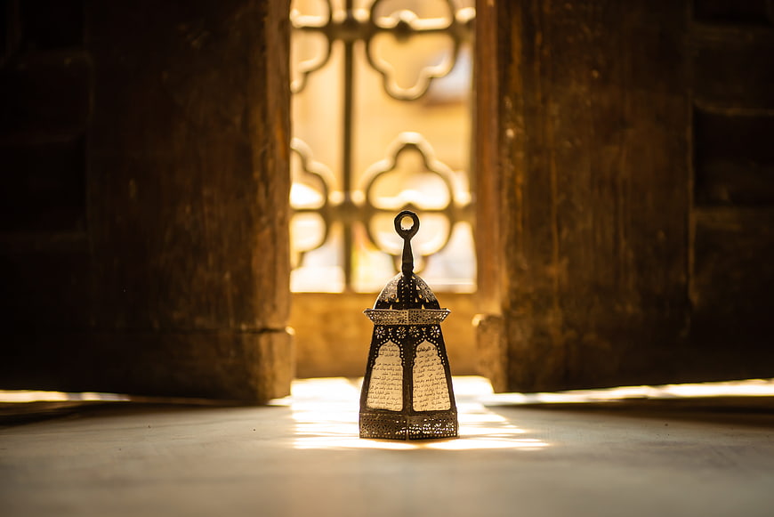 Traditional Ramadan Lantern in Sunlit Wooden Doorway