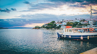 Boat Docked in Harbor with Coastal Town at Sunset
