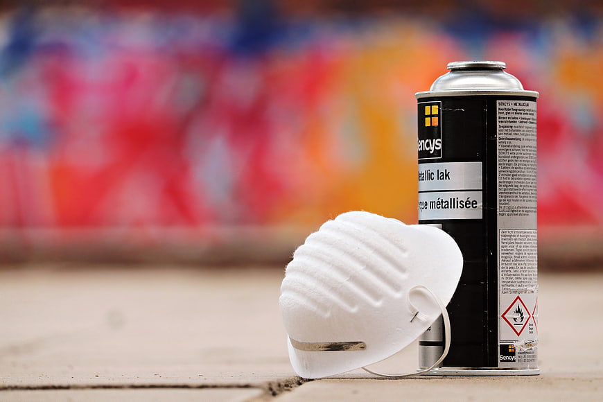 Spray Paint Can and Respirator Mask on Concrete