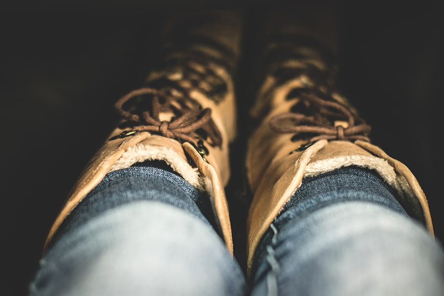 Close-up of brown leather boots and blue jeans