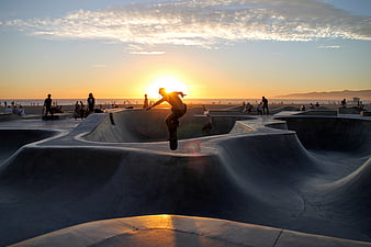 Skateboarder Silhouette Performing Trick at Sunset Beach Park