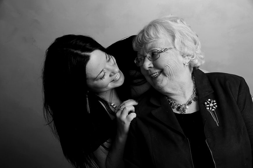 Black and white portrait of a smiling young woman and senior woman