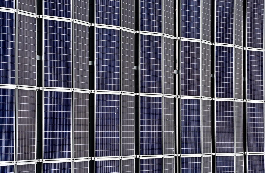 Close-up pattern of blue solar panels and silver frames