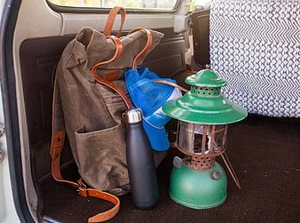 Vintage camping gear and backpack in car trunk