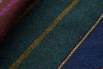 Close-up of textured striped fabric with teal and gold threads