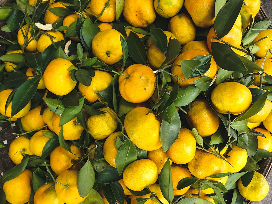 Top view of fresh tangerines with green leaves