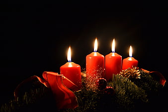 Lit Red Advent Wreath Candles With Pine And Ribbon On Black Background