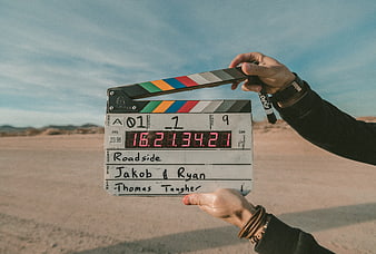 Film clapperboard held in desert landscape