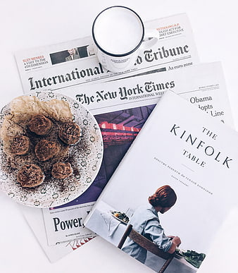Flat lay of coffee, truffles, and Kinfolk Table book on newspapers