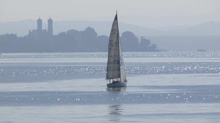 Sailboat Sailing on Lake Constance with Distant Castle Silhouette