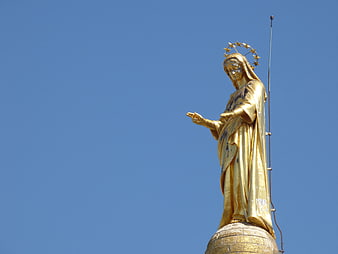 Golden Statue of Virgin Mary Against Blue Sky