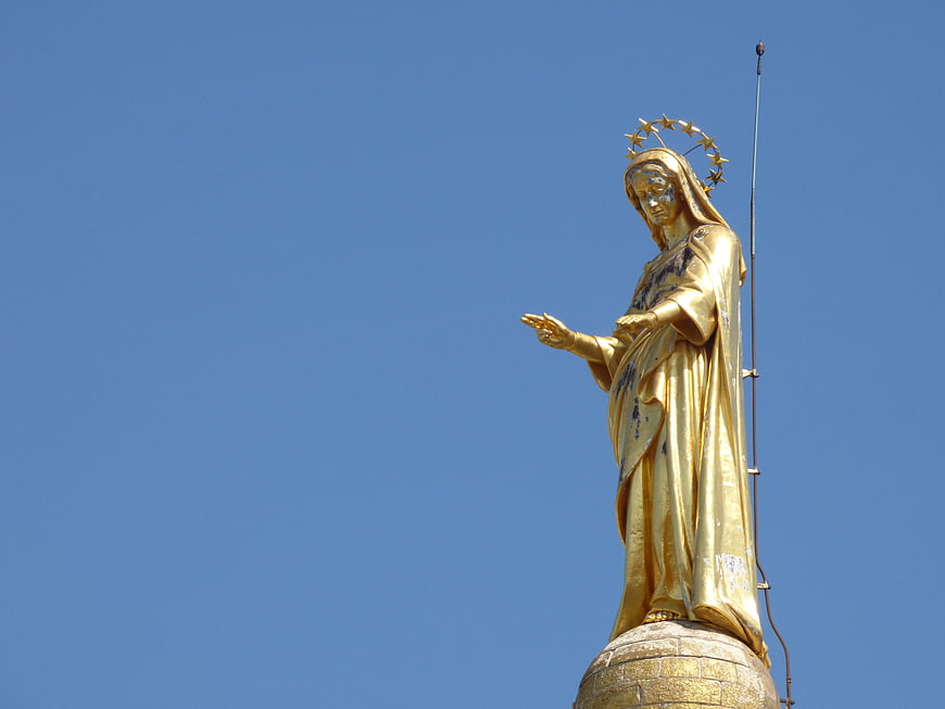 Golden Statue of Virgin Mary Against Blue Sky