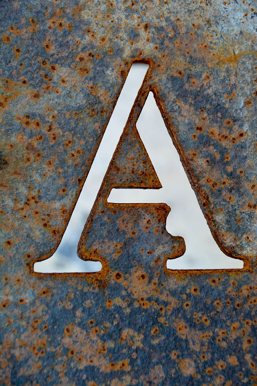 Rusty Metal Letter A Cutout on Weathered Steel Plate