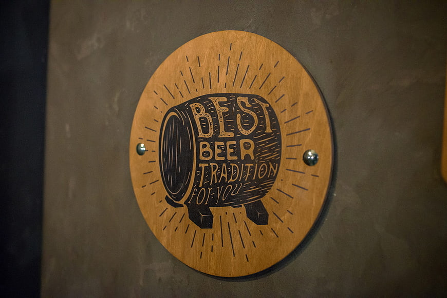 Engraved wooden beer barrel sign on wall