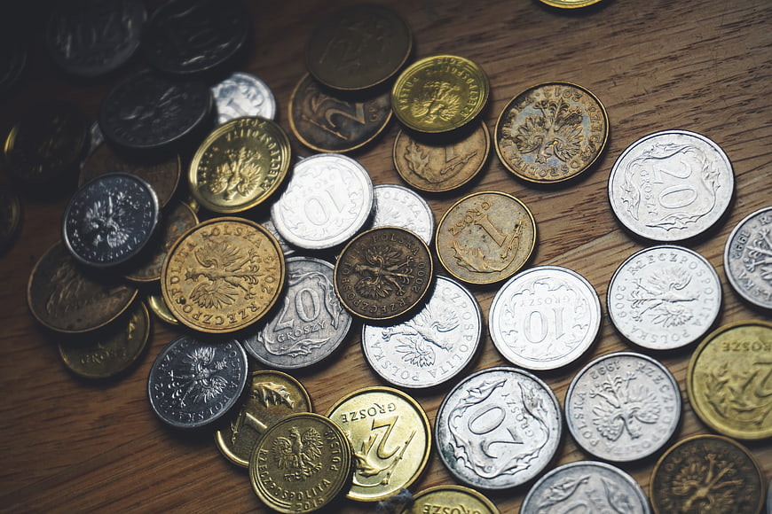 Scattered Polish Zloty Coins on Wooden Table