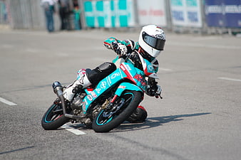 Motorcycle racer leaning into a turn on a race track