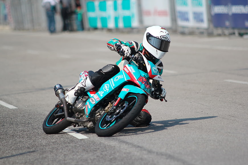 Motorcycle racer leaning into a turn on a race track