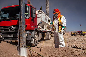 Worker in protective gear at desert drilling site