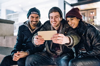 Happy friends taking selfie with smartphone outdoors