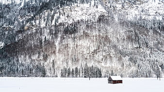 Solitary wooden cabin in snowy mountain valley winter landscape