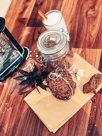 Chocolate oat cookies with milk on wooden table