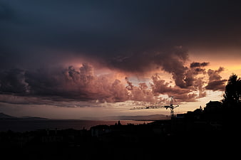 Dramatic Sunset Sky Over Coastal Construction Silhouette