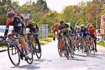 Cyclists racing on a wet road in a peloton