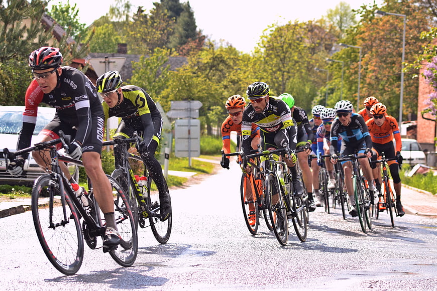 Cyclists racing on a wet road in a peloton