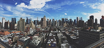 Panoramic New York City Skyline with Skyscrapers and Blue Sky