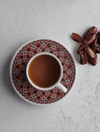 Top View of Coffee Cup with Dates on Patterned Saucer