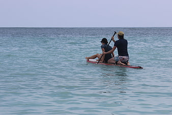 Couple Paddleboarding on Calm Blue Ocean Water