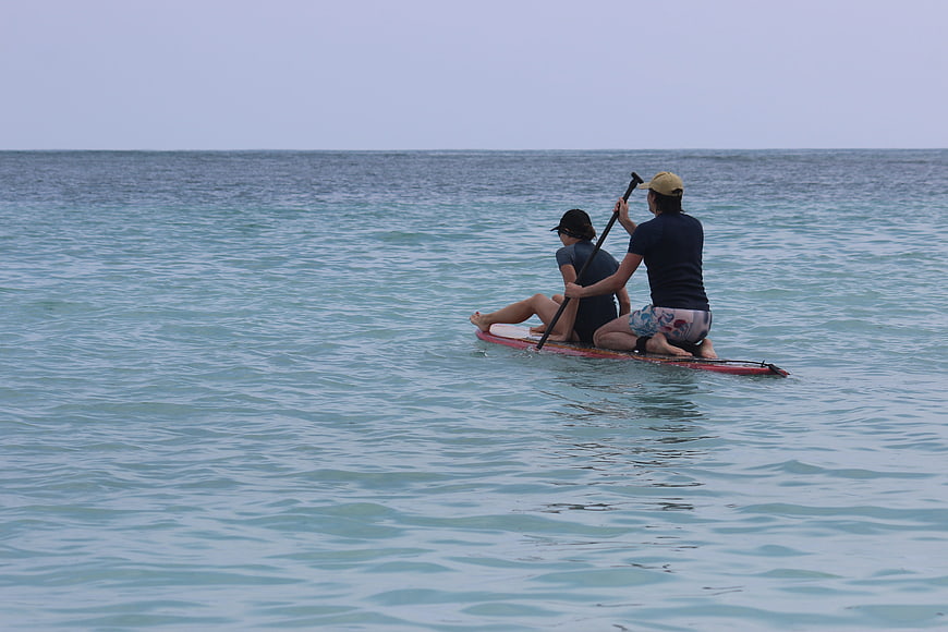 Couple Paddleboarding on Calm Blue Ocean Water