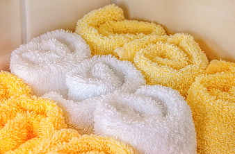 Rolled Yellow And White Fluffy Towels In A Storage Bin